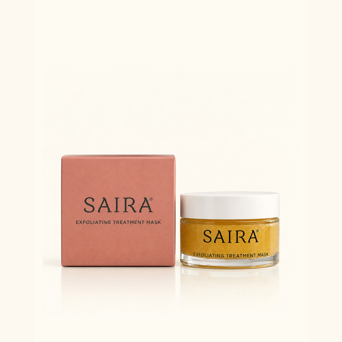 SAIRA Exfoliating Treatment Mask shown with its dusty pink packaging box and a clear glass jar containing a golden-yellow mask, set against a clean off-white background.
