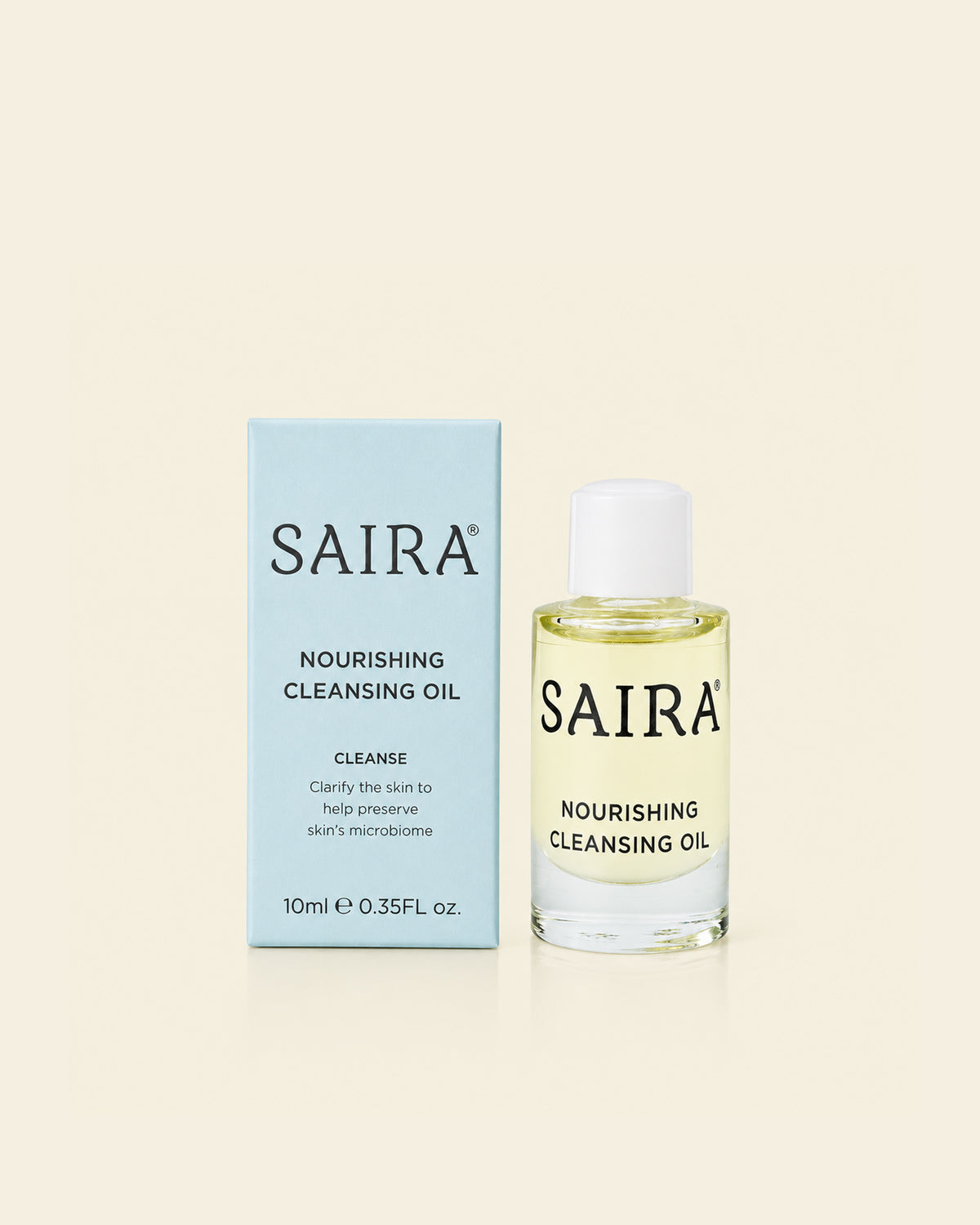 SAIRA Nourishing Cleansing Oil shown with its light blue outer box and the clear glass bottle containing pale yellow oil, set against a solid cream background.