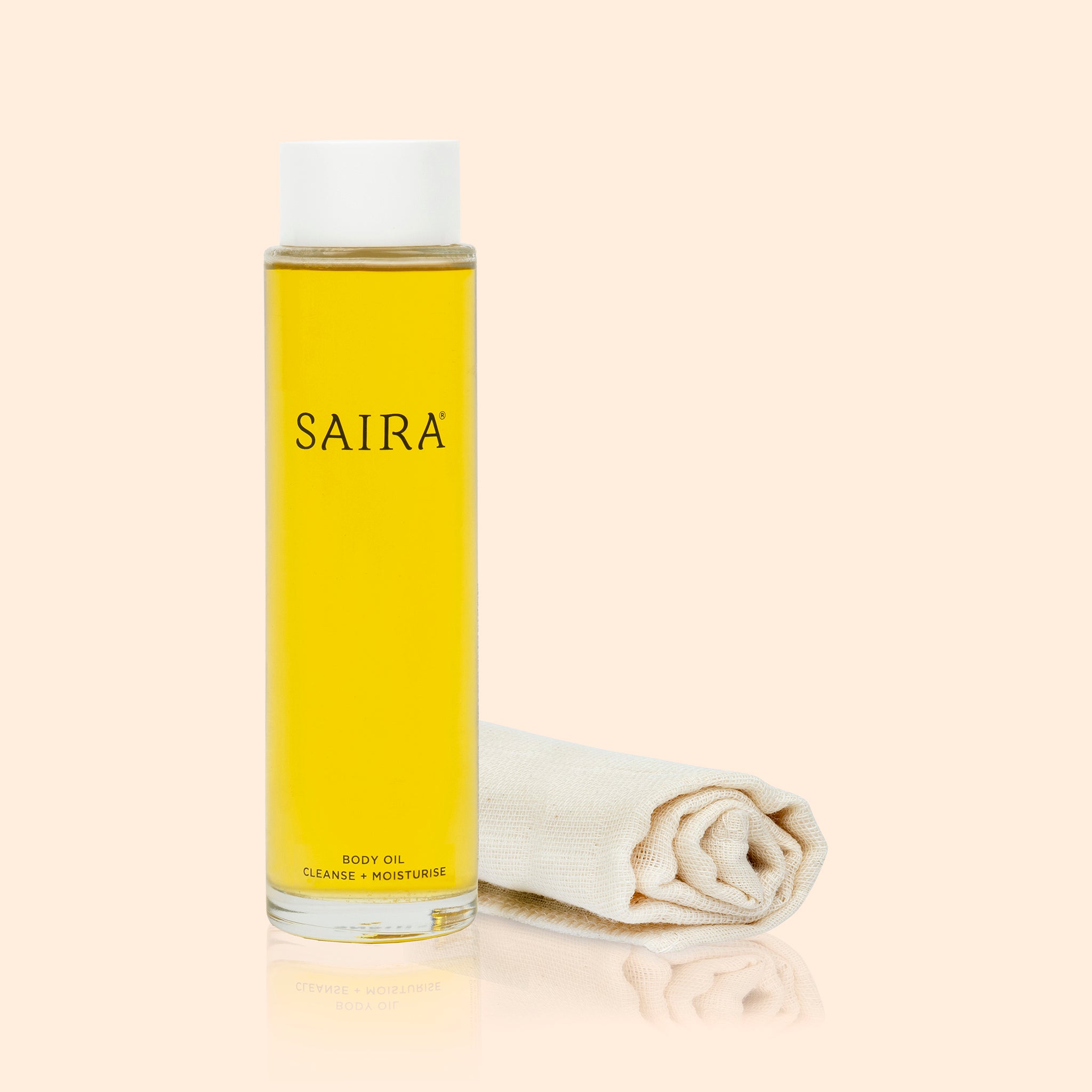 Bottle of Saira body oil wash with a white cap on a beige background