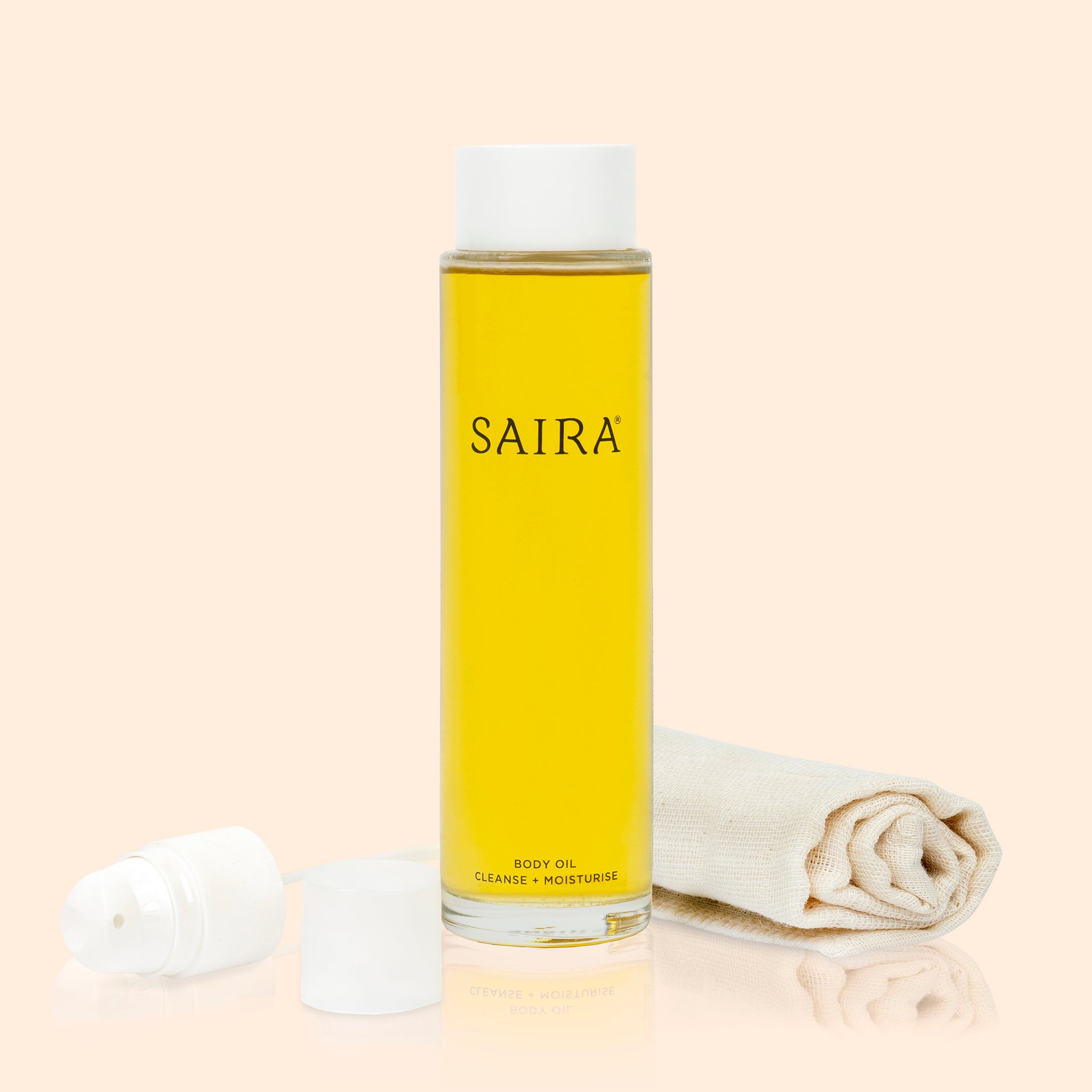 SAIRA body oil bottle with a white cap and muslin cloth on a beige background