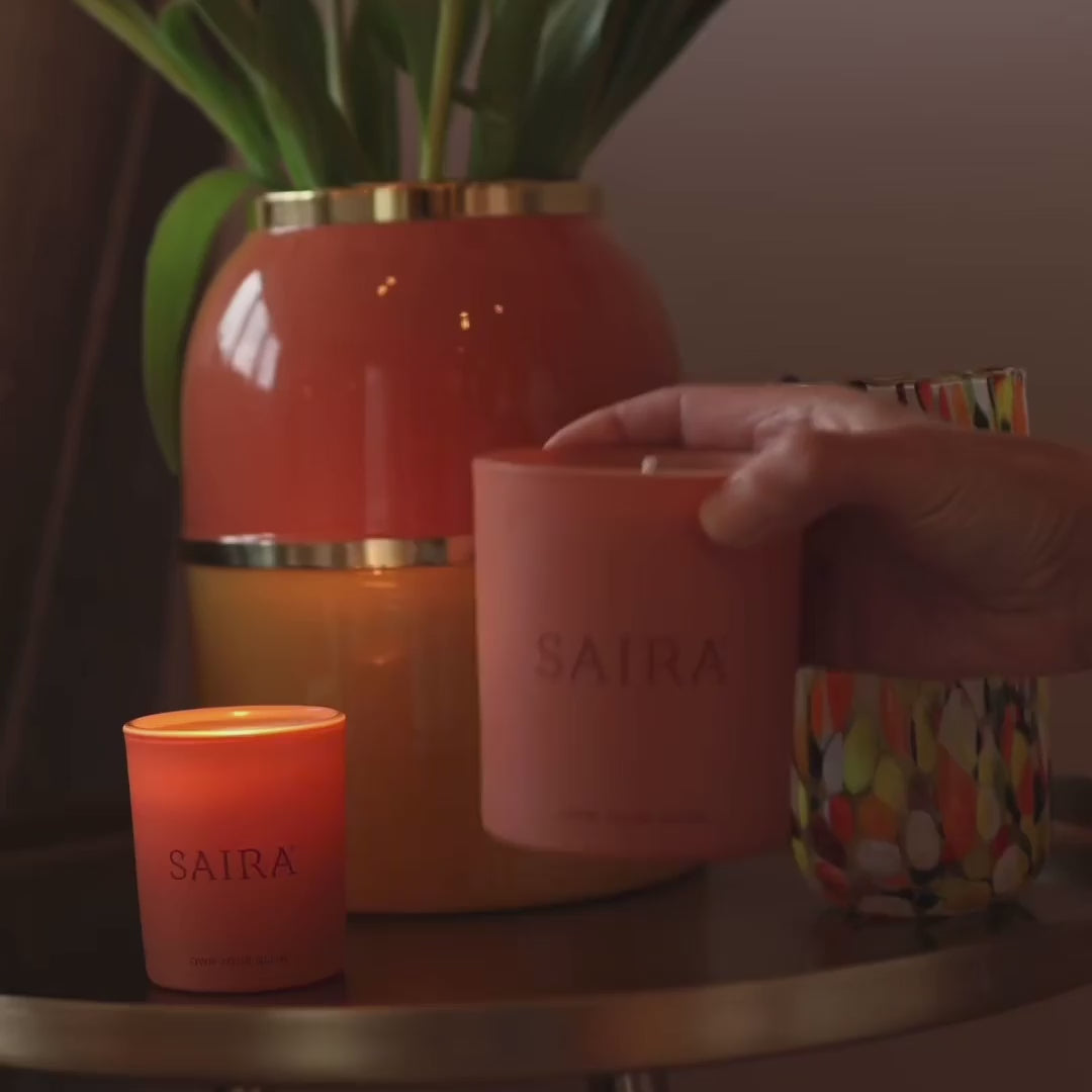 Load video: Saira products positioned in natural situations, against the bark of a birch tree, atop a large leaf on grass