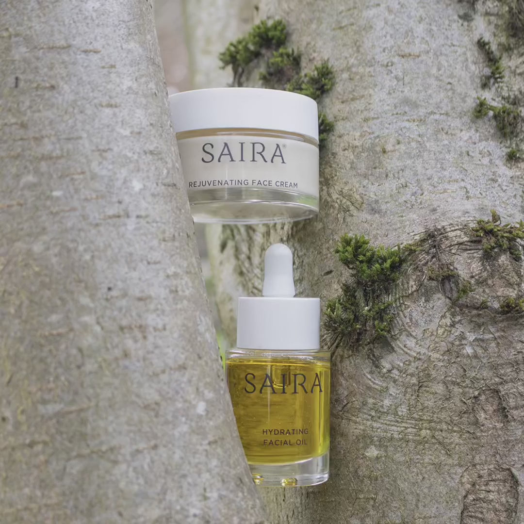 Load video: Saira products positioned in natural situations, against the bark of a birch tree, atop a large leaf on grass